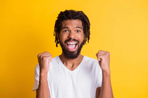 Foto de super alegre pele escura cara levantar punhos celebrar vitória desgaste casual t-shirt isolado cor amarela fundo — Fotografia de Stock