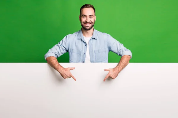 Retrato de chico optimista punto vacío espacio desgaste camisa azul aislado sobre fondo de color verde vibrante —  Fotos de Stock