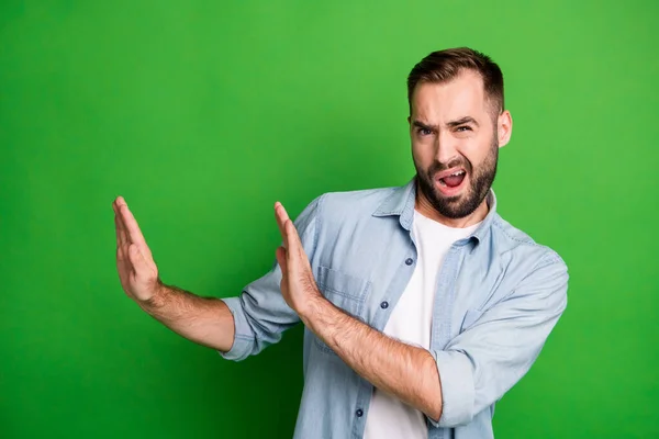 Retrato de tipo molesto no muestran ningún signo de desgaste camisa azul aislado en el fondo de color verde vibrante — Foto de Stock