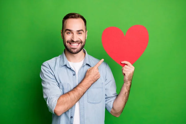 Portré optimista srác pont piros szív visel kék ing elszigetelt élénk zöld színű háttér — Stock Fotó