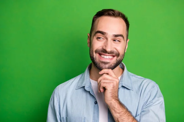 Retrato de hombre divertido optimista usar camisa azul mirada espacio vacío barbilla de mano aislado sobre fondo de color verde — Foto de Stock