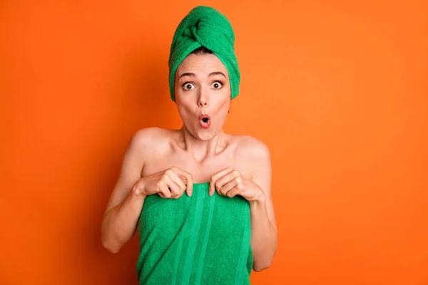 Φωτογραφία της νεαρής χαριτωμένης κυρίας σοκαρισμένο πρόσωπο χέρια κρατήσει πτώση πετσέτα φορούν πράσινο τουρμπάνι απομονωμένο πορτοκαλί χρώμα φόντο — Φωτογραφία Αρχείου