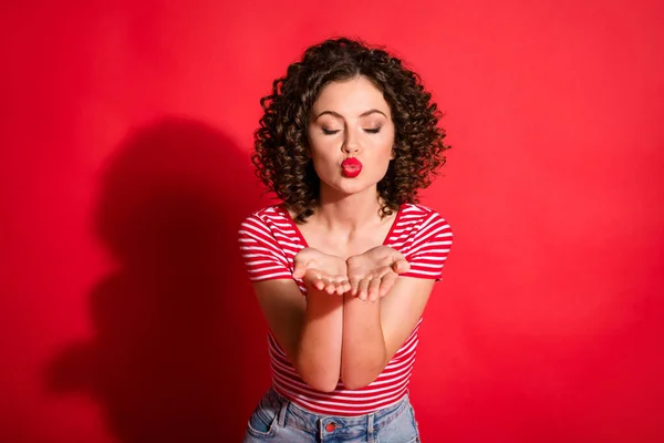 Φωτογραφία από υπέροχη κυματιστή νεαρή γυναίκα ντυμένη ριγέ στολή στέλνοντας σας φιλί κλειστά μάτια απομονωμένο φόντο κόκκινο χρώμα — Φωτογραφία Αρχείου