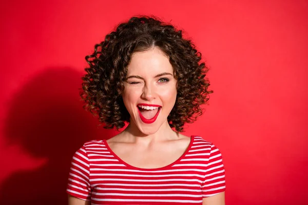 Flört eden komik, dalgalı, çizgili giyinmiş, ağzı açık kırmızı arka plan renginde genç bir kadının fotoğrafı. — Stok fotoğraf