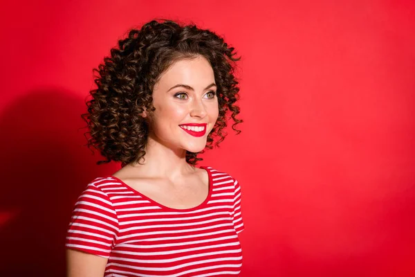 Profil côté photo de jeune joyeuse jeune dame sourire positif regarder espace vide isolé sur fond de couleur rouge — Photo