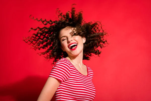 Foto av ung söt flicka glad leende lockigt brunt hår vind njuta schampo vård isolerad över röd färg bakgrund — Stockfoto
