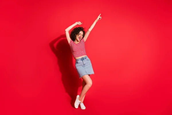 Helkroppsfoto av ung positiv flicka njuta peka finger tomt utrymme skrika bära mini kjol isolerad över röd färg bakgrund — Stockfoto