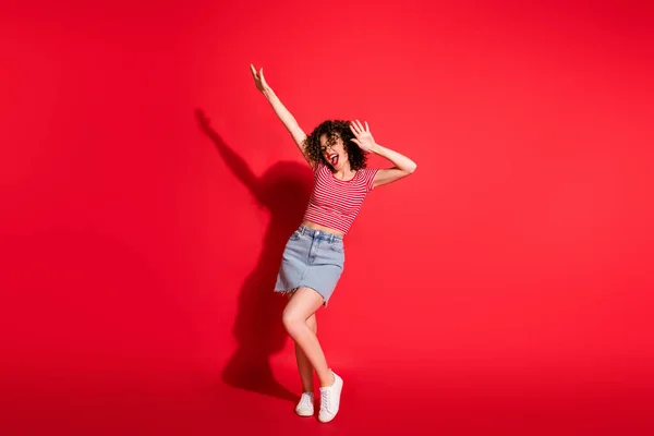 Foto de corpo inteiro de jovem menina atraente se divertir dança desfrutar de mãos para cima gritar isolado sobre fundo de cor vermelha — Fotografia de Stock