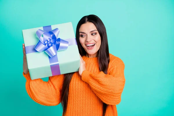 Foto de la señora loca emocionada celebrar caja de regalo boca abierta desgaste jersey naranja aislado color turquesa fondo —  Fotos de Stock