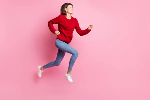 Retrato de cuerpo de longitud completa de chica bonita saltando alto vistiendo traje casual sonriendo corriendo rápido aislado sobre fondo de color rosa — Foto de Stock
