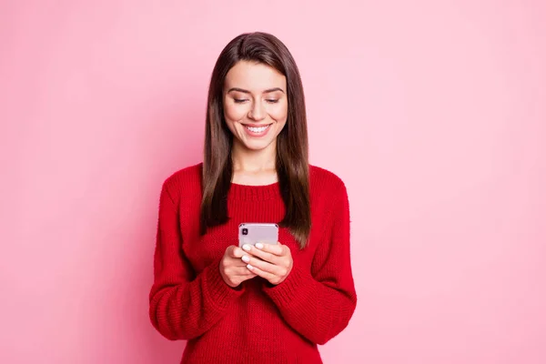 Фото красивої молодої леді тримає телефонний вигляд екрану біла посмішка носить червоний светр ізольований рожевий кольоровий фон — стокове фото