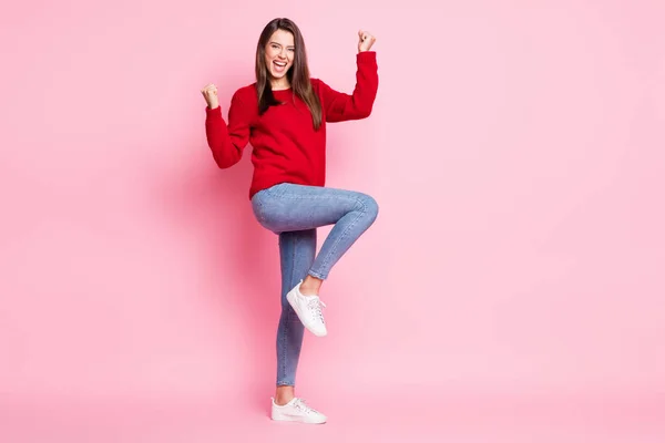 Foto de longitud completa de la encantadora señora boca abierta levantar los brazos ropa de rodilla suéter rojo jeans zapatillas aisladas de color rosa fondo — Foto de Stock