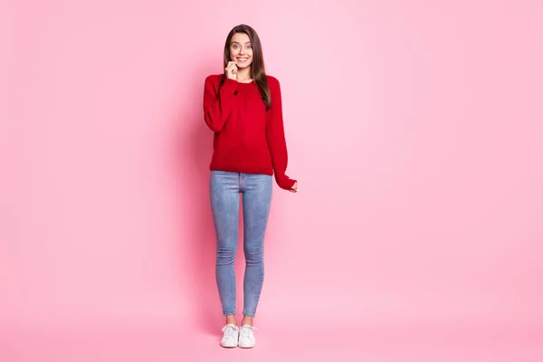 Foto de longitud completa de las manos de la señora bonita manga del pómulo sonrisa brillante usar suéter rojo jeans zapatillas aisladas de color rosa fondo —  Fotos de Stock