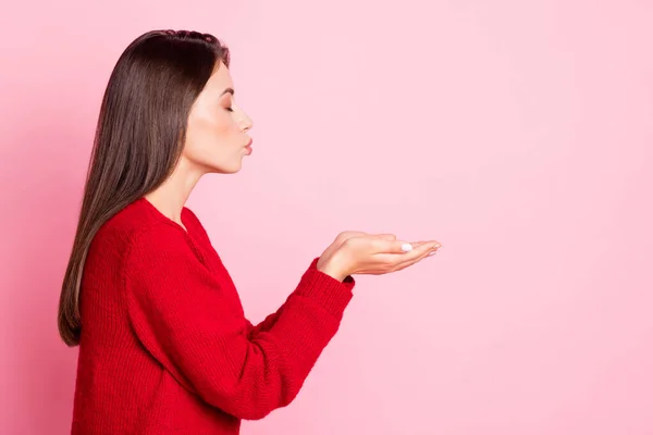 Perfil foto de jovem encantador menina sonhador sopro ar beijo palmas vazio espaço desgaste vermelho suéter isolado cor-de-rosa fundo — Fotografia de Stock