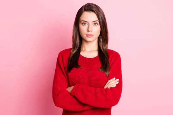 Foto retrato de la joven tranquila chica bonita con la cara seria cruzó las manos usando suéter rojo aislado en el fondo de color rosa —  Fotos de Stock