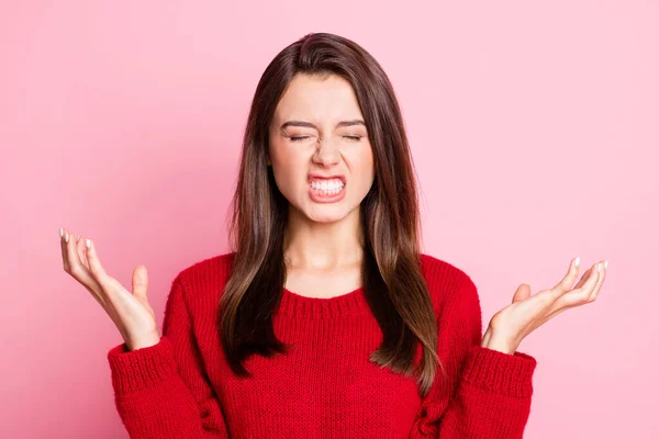 Ritratto foto di nervosa irritata indignata giovane ragazza vestita di rosso gesticolando con entrambe le mani sorridendo con gli occhi chiusi isolati su sfondo di colore rosa — Foto Stock