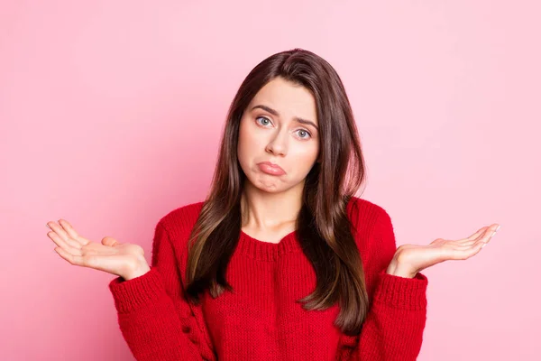 Foto portret van verdrietig ongelukkige meisje houden beide handen in de buurt van schouders als doesnt weten het dragen van rode trui geïsoleerde roze kleur achtergrond — Stockfoto