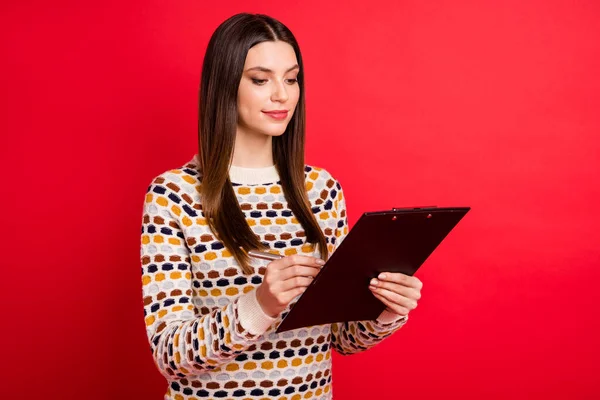 Portret optymistycznej dziewczyny napisać papier nosić kolorowy sweter izolowany na czerwonym tle — Zdjęcie stockowe