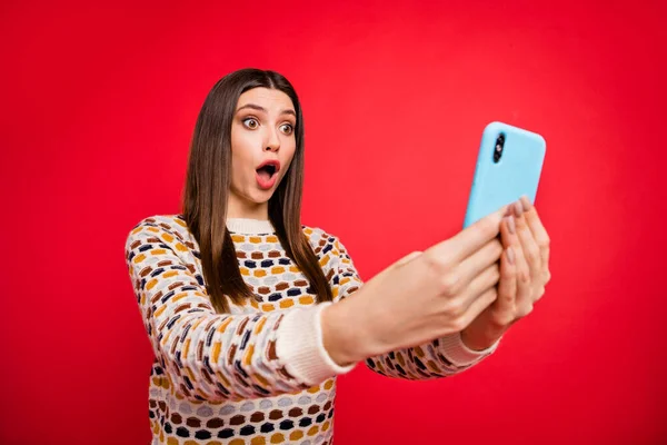 Retrato de impressionado triste menina olhar telefone desgaste colorido suéter isolado na cor vermelha fundo — Fotografia de Stock