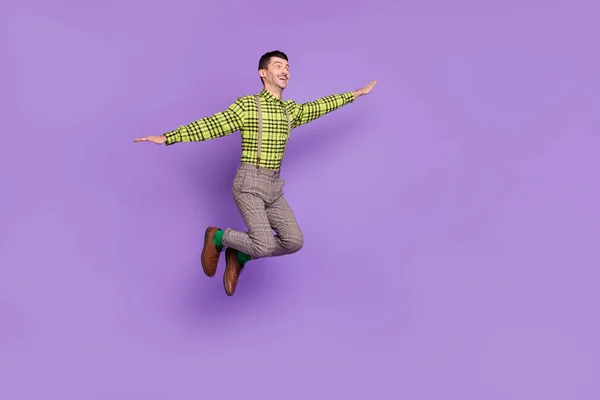 Full size profilo lato foto di giovani felici eccitato positivo buon umore uomo saltare le ali delle mani isolato su sfondo di colore viola — Foto Stock