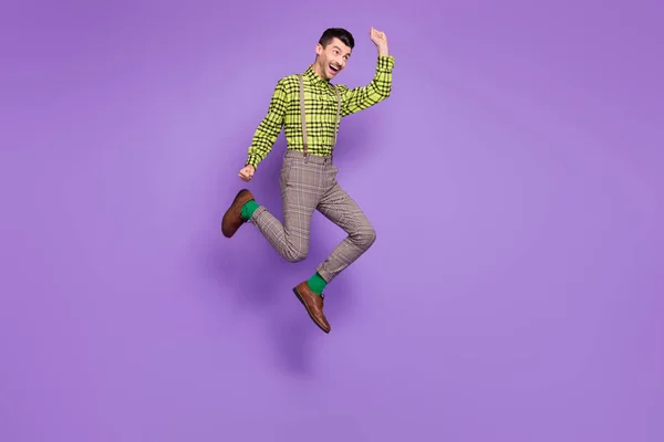 Profilo full size lato foto di giovane felice positivo pazzo sorridente uomo saltare in vittoria isolato su sfondo di colore viola — Foto Stock