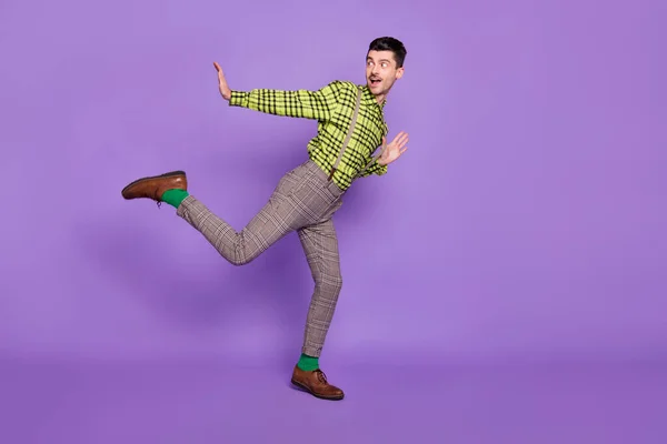 Profilo full size lato foto di giovane felice buon umore positivo uomo danza guardare copyspace isolato su sfondo di colore viola — Foto Stock