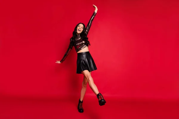 Повна довжина фотографії дівчини танець підняти руки носять глянцевий верхній шкіряний короткий спідничний взуття ізольований червоний колір фону — стокове фото