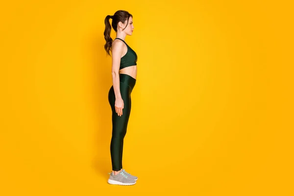 Volledige lengte lichaamsgrootte profiel zijaanzicht van mooie sportieve gezonde meisje staande recht geïsoleerd over levendige gele kleur achtergrond — Stockfoto