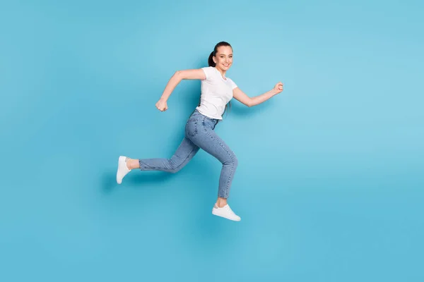 Full body profile side photo of charming girl jump run copyspace after season discounts wear good look outfit isolated over blue color background