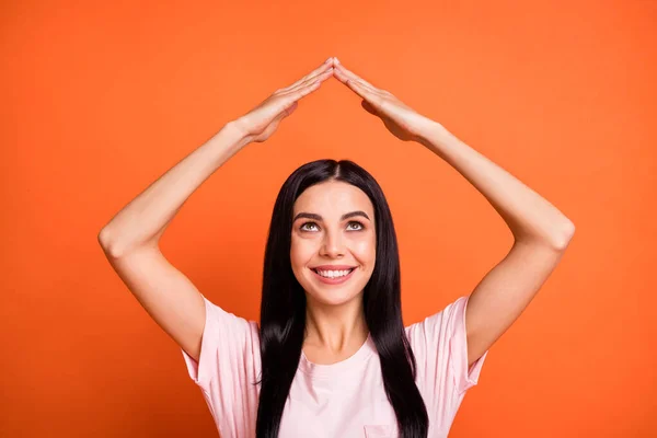 Pozitif kadının portresi kollarını kaldır ev figürünün ışıltısını turuncu arka planda izole et. — Stok fotoğraf