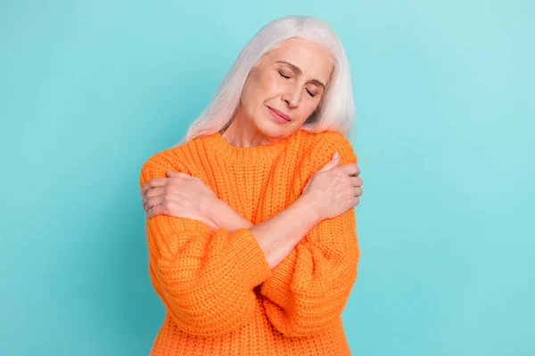 Portrait of attractive dreamy calm grey-haired woman hugging herself cosy wear isolated over teal turquoise bright color background