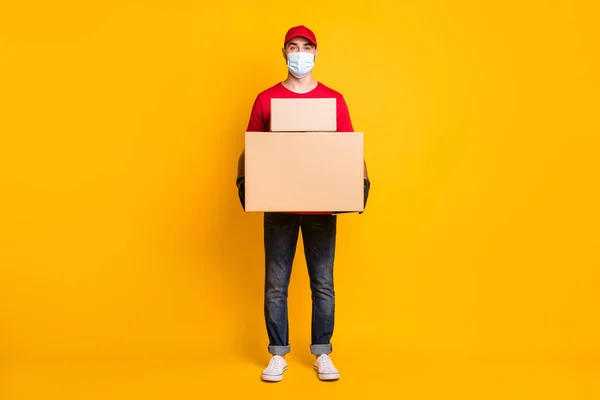 Full length body size view of nice guy mailman bringing big parcels fast shipping wear mask health care isolated over vivid yellow color background — Foto Stock