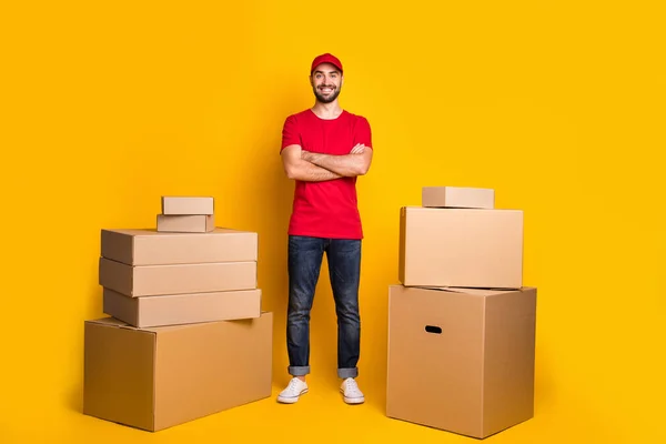 Full length body size photo happy courier with crossed hands packing delivery boxes isolated on vivid yellow color background — Foto Stock