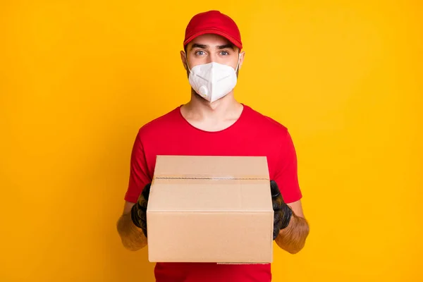 Portrait of healthy guy wear n95 respirator bringing parcel shop store order stop pandemia concept isolated on vivid yellow color background — Foto Stock