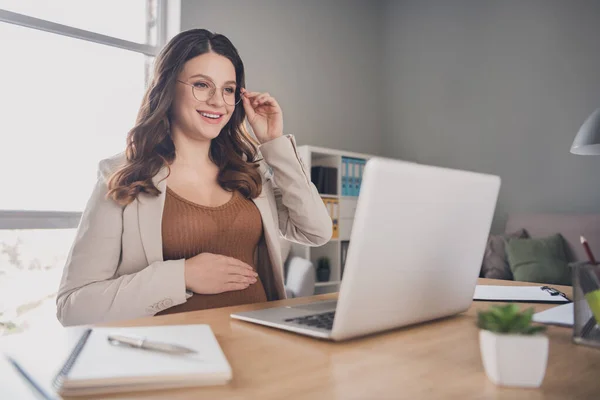 Foto portrét těhotné ženy dotýkající se brýlí pracující na notebooku čtení v moderní kanceláři — Stock fotografie