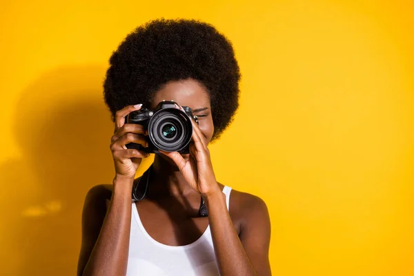 Nahaufnahme Porträt eines hübschen welligen brünetten Mädchens mit Digitalkamera, das Fotos macht, die isoliert über einem leuchtend gelben Hintergrund einrasten — Stockfoto