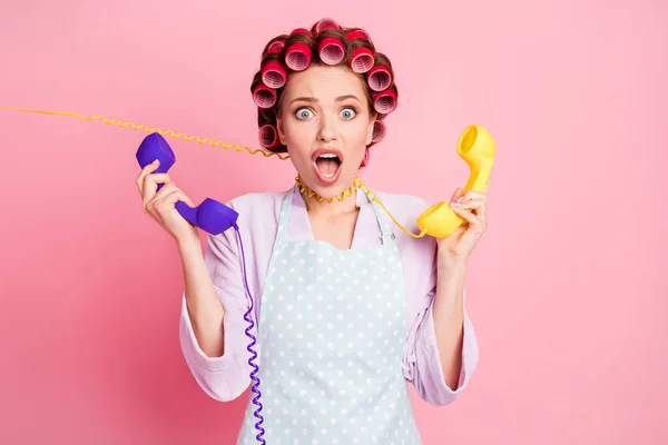 Portré frusztrált hölgy tart két régi telefon kábel körül nyak pánik nyitott száj elszigetelt rózsaszín színű háttér — Stock Fotó