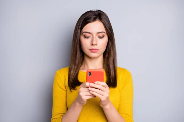 Фото молодої серйозної привабливої чарівної дівчини з використанням смартфона одягнений яскравий светр ізольований на сірому кольоровому фоні — стокове фото