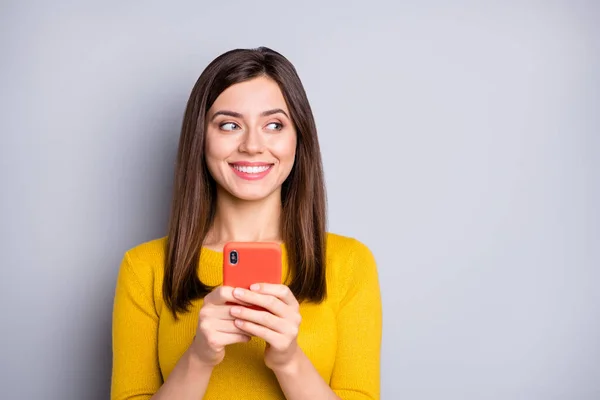 Retrato de contenido atractivo chica alegre usando gadget mirando a un lado espacio de copia aislado sobre fondo de color gris — Foto de Stock