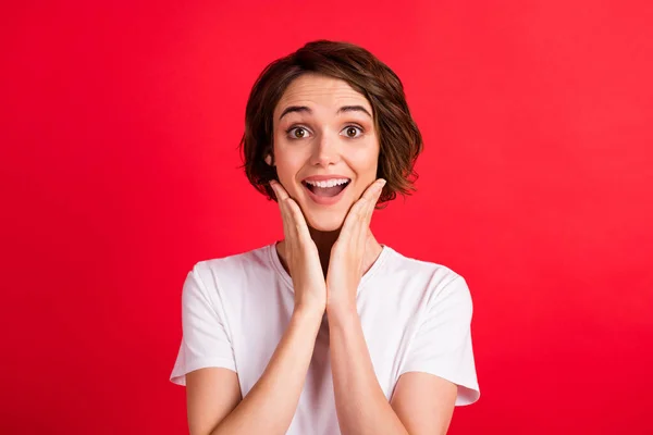 Portret van aantrekkelijke vrolijke verbaasd meisje genieten van goed nieuws verkoop geïsoleerd over helder rood kleur achtergrond — Stockfoto