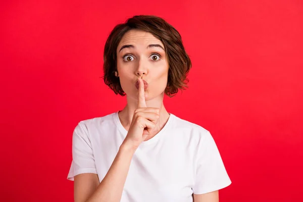 Retrato de chica curiosa asombrada atractiva mostrando shh signo oops aislado sobre fondo de color rojo vibrante — Foto de Stock