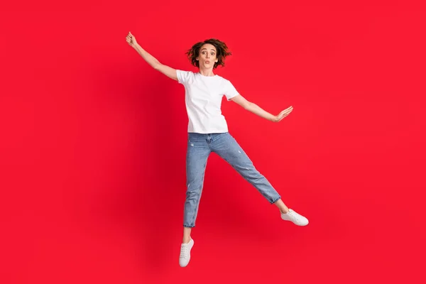 Longitud completa vista del tamaño del cuerpo de agradable chica flaca divertida saltando divertirse sosteniendo sombrilla invisible aislado sobre fondo de color rojo brillante — Foto de Stock