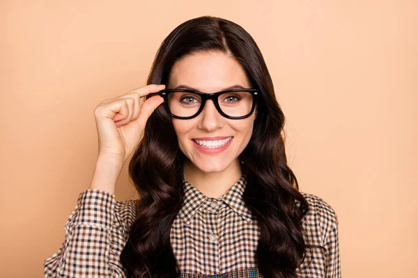 Retrato de lindo alegre menina de cabelos ondulados desgaste tocando especificações conhecimento isolado sobre fundo cor pastel bege — Fotografia de Stock