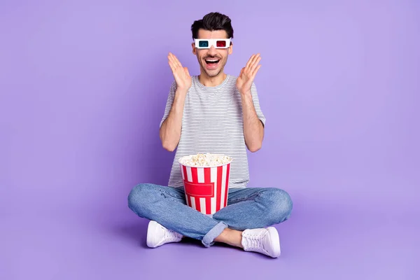 Фото парня держать попкорн коробка с открытым ртом поднять пальмы носить 3D очки футболки джинсы обувь изолированный фиолетовый фон — стоковое фото
