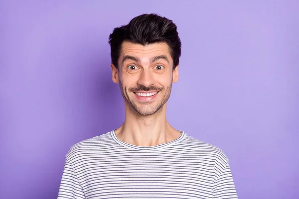 Foto de joven guapo radiante sonrisa usar negro y blanco rayas camiseta aislado fondo púrpura — Foto de Stock