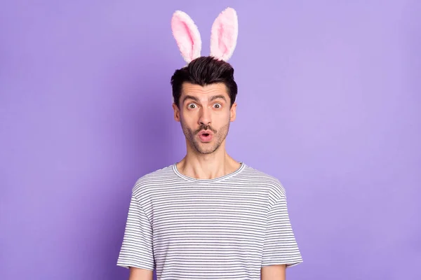 Foto van geschokte man open mond kijken camera slijtage haas oren hoofdband wit gestreept t-shirt geïsoleerde paarse achtergrond — Stockfoto