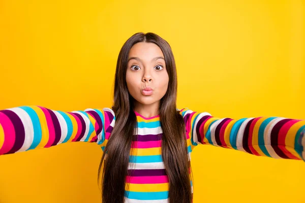 Foto de menina pequena fazer selfie enviar ar beijo engraçado rosto desgaste listrado camisa isolada cor amarela fundo — Fotografia de Stock