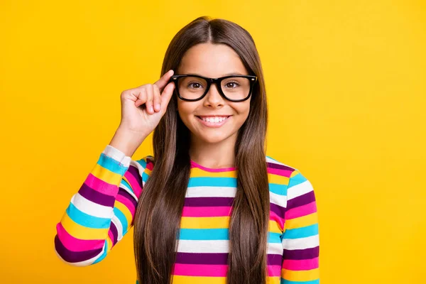 Foto portret van leuke slimme schoolmeisje aanraken bril glimlachen gelukkig geïsoleerd op levendige gele kleur achtergrond — Stockfoto