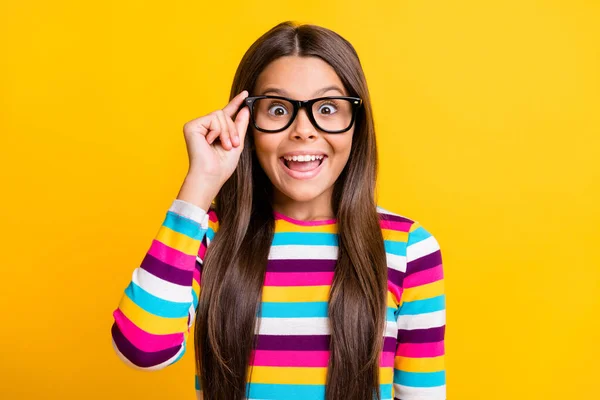 Foto portret van gelukkig geschokt schoolmeisje aanraken bril staren met geopende mond glimlachen geïsoleerd op levendige gele kleur achtergrond — Stockfoto