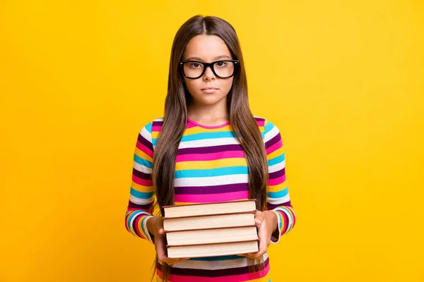 写真ポートレートの穏やかな深刻な女子高生の勉強のための本の山を保つための眼鏡を身に着けている鮮やかな黄色の背景 — ストック写真